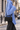 Lia in Shadow Black worn with a blue knit on a city street